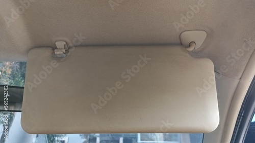 Sun visor in modern cars to prevent the sun's rays from shining into the eyes while driving. Sun visor in the front area of the car above the driver. car interior with cream color. photo