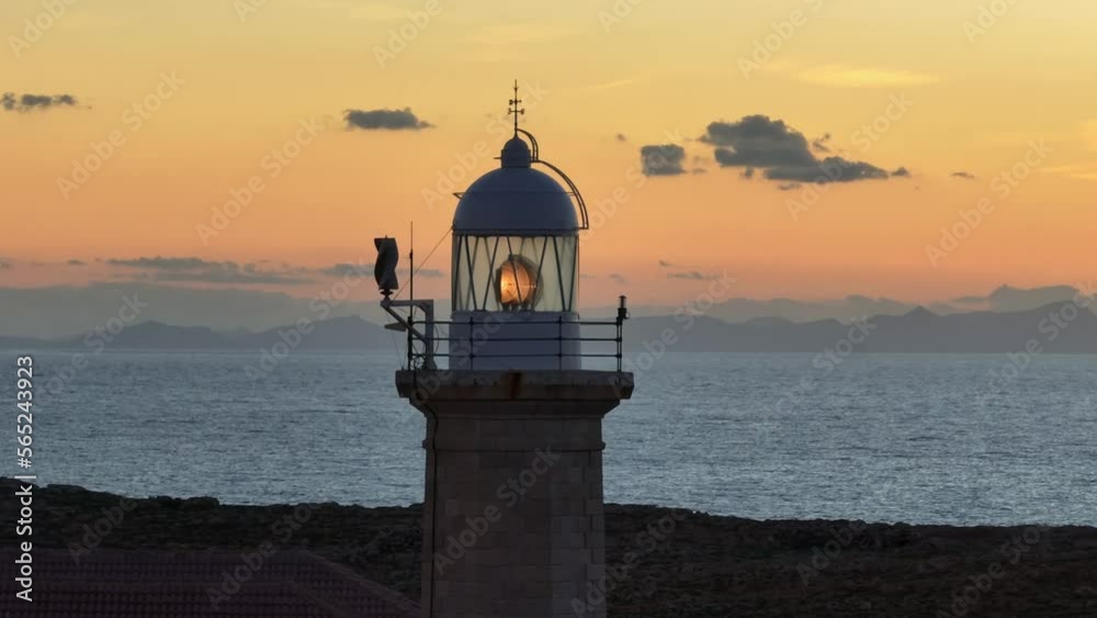 Long aerial zoom of Punta Nati Lighthouse in Spain. Beautiful sunset over Mediterranean sea. Long aerial zoom of Punta Nati Lighthouse in Spain. Beautiful sunset over Mediterranean sea.