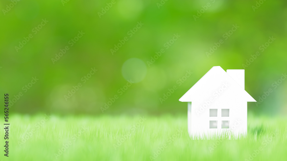 芝生の上の白い小さいおもちゃの家。住宅、不動産、戸建て、新生活のイメージ。（横長）	