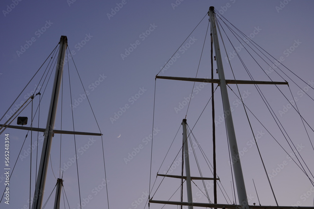 The masts of the ships and yachts in the marina are towards the horizon, with a view of nature in the background. The masts of the ships and yachts in the marina are towards the horizon, with a view of nature in the background.