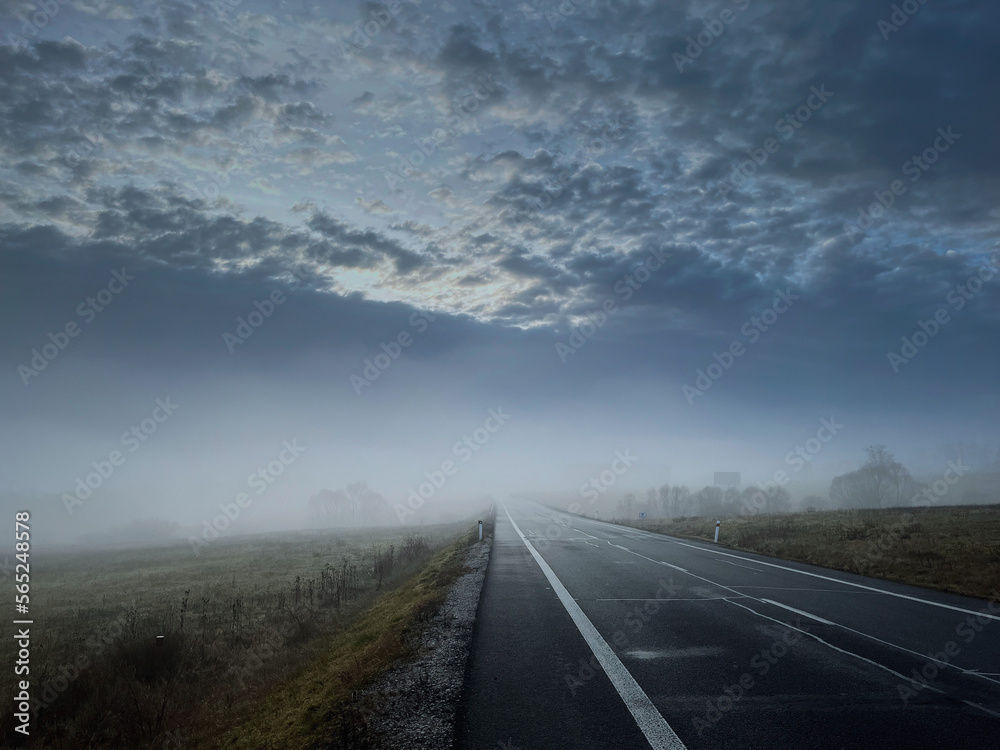 Misty cold road in blue winter morning