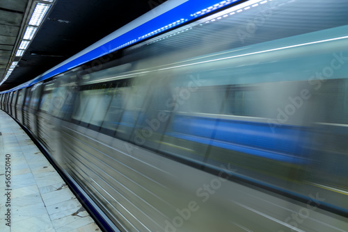Blurred motion of the train in underground station of subway. Long exposure of an underground train in a train station. Urban scene, city life, public transport and traffic concept