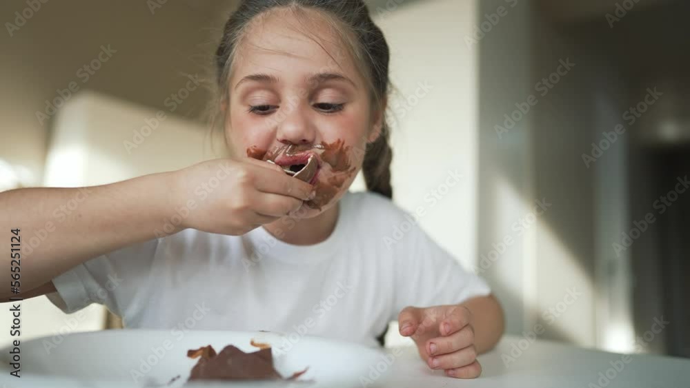 Boy and girl rides cocoa chocolate. Sweet breakfast at table in the kitchen. Dirty face of child. Happy family concept. Cheerful hungry children eat chocolate. Child eat chocolate sitting at table