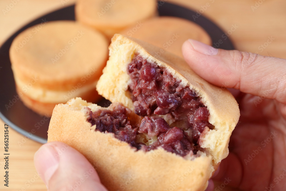 Closeup of Hand Splitting Tasty Japanese Azuki Bean Paste Filled Dessert Called Imagawayaki or Obanyaki Closeup of Hand Splitting Tasty Japanese Azuki Bean Paste Filled Dessert Called Imagawayaki or Obanyaki