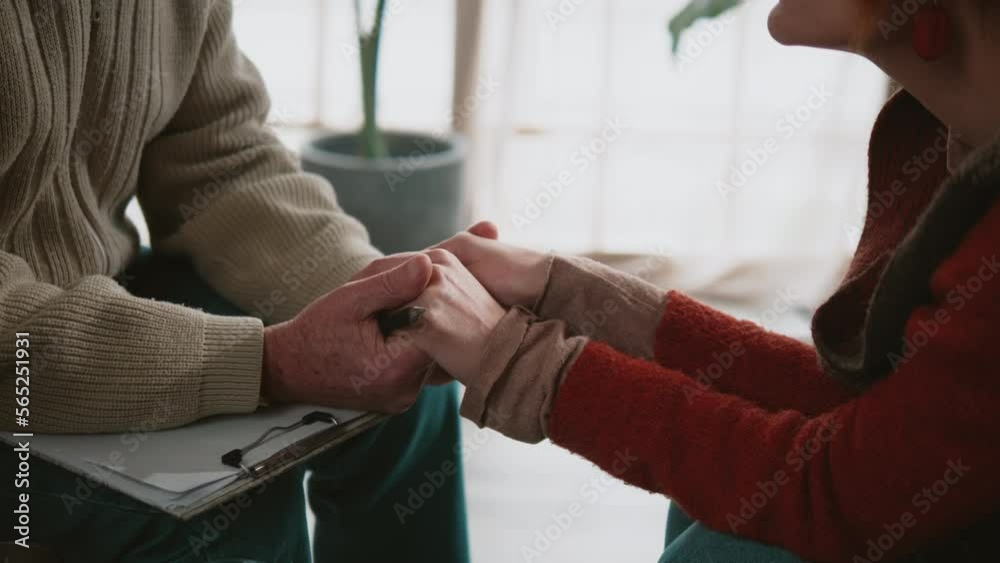 Close-up, male psychologist sitting and touching hands depressed  women