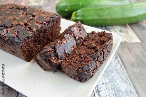 Zucchini chocolate cake. Moist double chocolate cake with grated zucchini, cocoa powder, chocolate and chocolate chips. Shot on wooden background