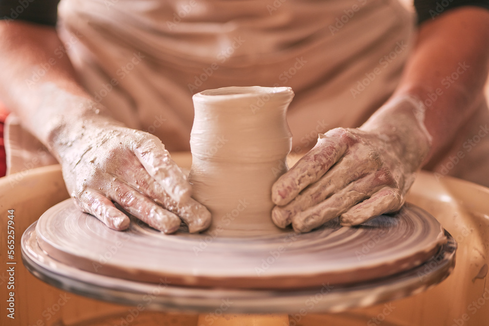 Hands, pottery and clay mold on table for creative art design, product or sculpture for startup workshop. Hand of crafty artist molding ceramic material in creation, shape or tool with spinning wheel