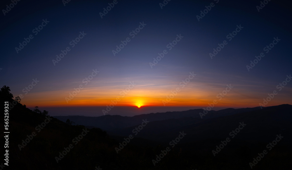 Panorama Aerial view big sun , sunrise over dark mountain with fog over the ground.The early evening sun illuminates the mountains and valleys.