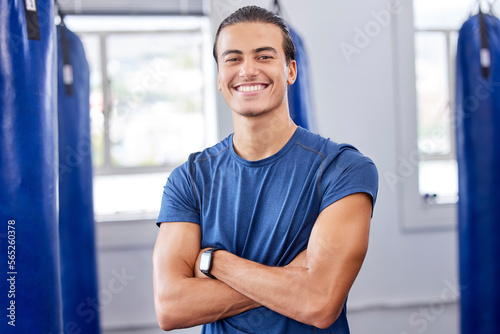 Personal trainer man, gym portrait and arms crossed with focus, wellness and health in workplace. Happy coach, smartwatch and strong mindset for exercise, mma and boxing training in workout studio