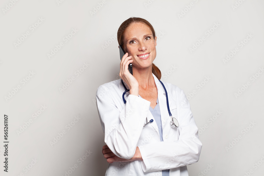 Modern female portrait of happy successful attractive mature adult woman doctor medical practitioner worker with smart phone in her hand Modern female portrait of happy successful attractive mature adult woman doctor medical practitioner worker with smart phone in her hand