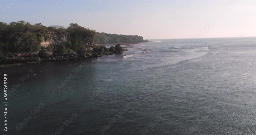 Rocky ocean coast with azure water on sunny day at sunset time. Bukit peninsula with some beaches. Aerial view, drone shot Rocky ocean coast with azure water on sunny day at sunset time. Bukit peninsula with some beaches. Aerial view, drone shot