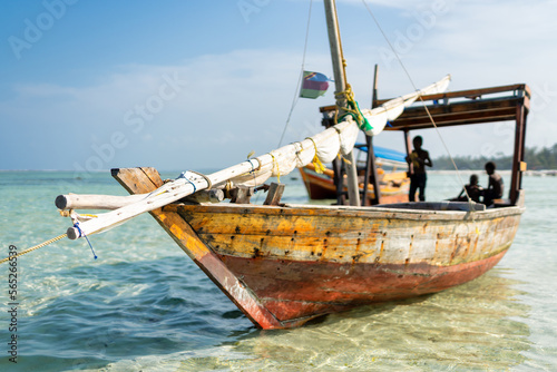Wooden fisherman boats on sandy beach with blue water background, Zanzibar, Tanzania
