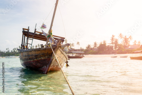 Fototapeta Naklejka Na Ścianę i Meble -  Wooden fisherman boats on sandy beach with blue water background, Zanzibar, Tanzania
