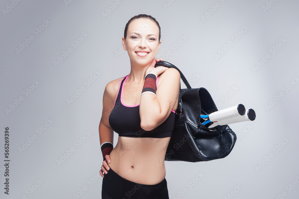 Tennis Concepts. Positive Winsome Professional Caucasian Tennnis Player Posing With Tennis Bag and Rockets Equipped in Sport Outfit Against White Tennis Concepts. Positive Winsome Professional Caucasian Tennnis Player Posing With Tennis Bag and Rockets Equipped in Sport Outfit Against White