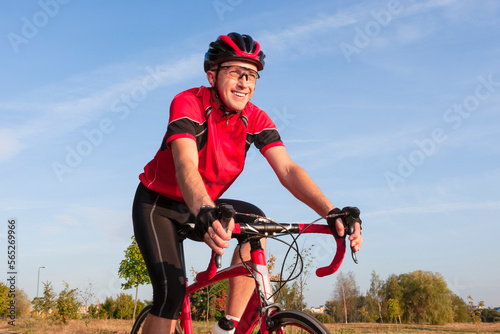 Road Cycling. One Emotional Male Cyclist Riding Road Bike Uphill Equipped with Summer Bike Outfit Posing Outdoor During Training.