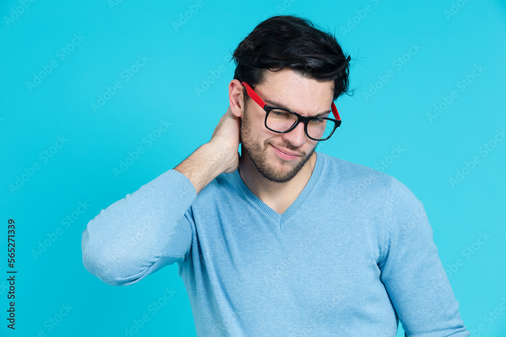 One Confident Caucasian Handsome Brunet Man Lifted Hand Scratching His Neck While Showing Negative Facial Expression Looking Downwards Against Blue One Confident Caucasian Handsome Brunet Man Lifted Hand Scratching His Neck While Showing Negative Facial Expression Looking Downwards Against Blue