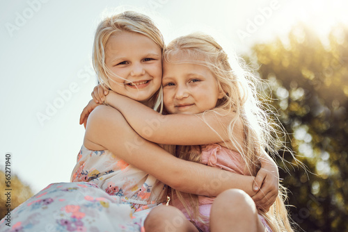 Hug, nature and portrait of girl siblings bonding, hugging and playing together in a park. Happy, smile and sisters embracing with care, love and friendship in a green garden on holiday in Canada. photo