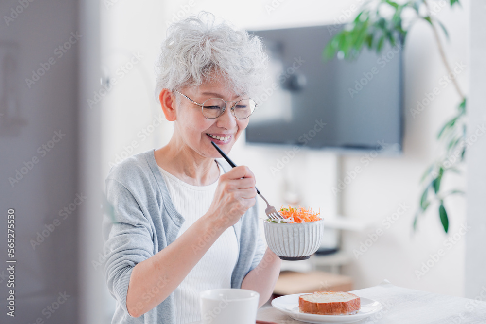 笑顔で朝食を食べるシニアの女性 笑顔で朝食を食べるシニアの女性