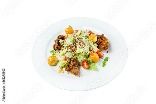 Salad with fresh vegetables in a white plate. Appetizing spring dish. Close-up. Top view. Isolated on white background.