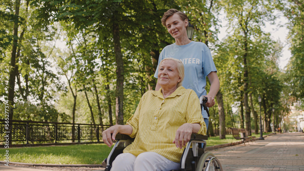 Female volunteer taking care of senior woman with disability in a retirement home Female volunteer taking care of senior woman with disability in a retirement home