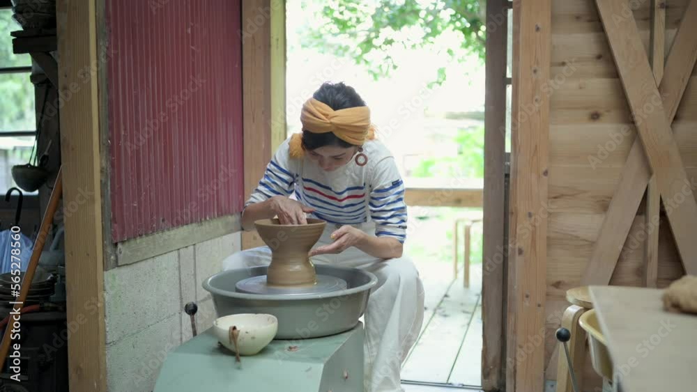 ろくろを回して作品作りに取り組んでいる芸術家の女性 ろくろを回して作品作りに取り組んでいる芸術家の女性