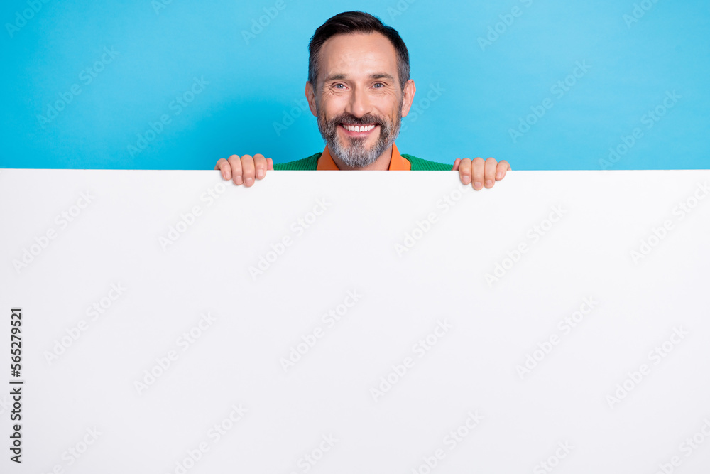 Photo of smiling good mood grey beard businessman hold paper big placard empty space new medicine clinic brand isolated on blue color background Photo of smiling good mood grey beard businessman hold paper big placard empty space new medicine clinic brand isolated on blue color background