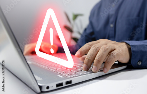 Fototapeta Naklejka Na Ścianę i Meble -  Businessman using computer laptop with triangle caution warning sing for notification error and maintenance concept..