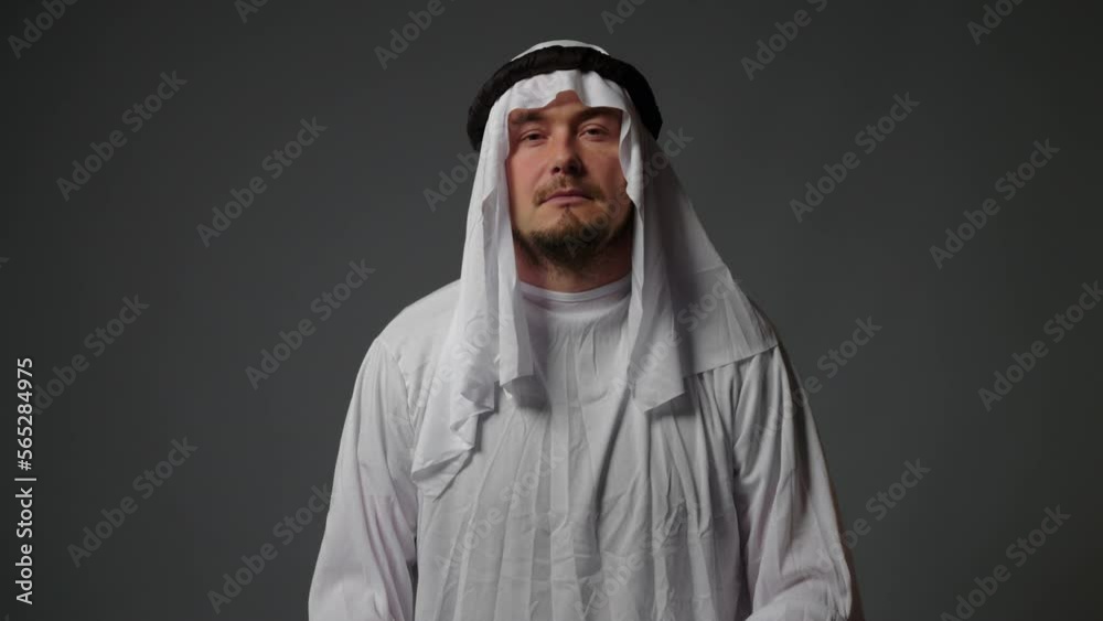 Portrait close up of successful arab man in traditional outfit, wearing white kandura and black agal looks at camera. Saudi, Emirati, Arab Businessman Concept Portrait close up of successful arab man in traditional outfit, wearing white kandura and black agal looks at camera. Saudi, Emirati, Arab Businessman Concept