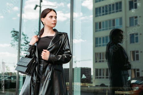 Pretty brunette caucasian woman dressed leather suit with shoulder bag walking outside street. Businesswoman hurry to work. Office CEO clerk. Confident serious lady. Professional business owner 