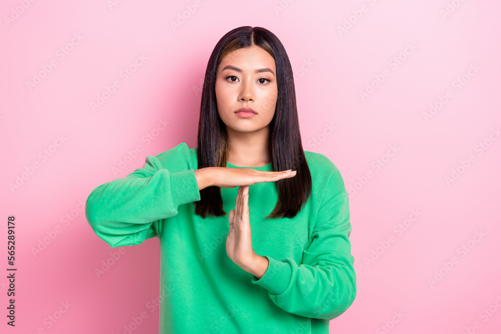 Photo of confident serious lady wear green sweatshirt showing arms palms time out sign isolated pink color background Photo of confident serious lady wear green sweatshirt showing arms palms time out sign isolated pink color background