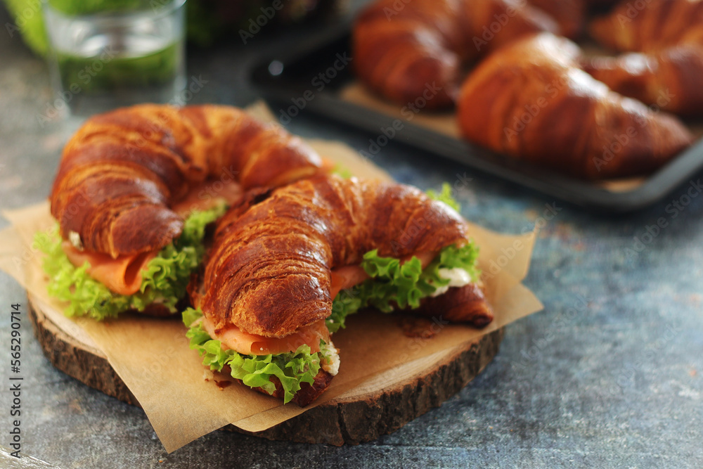 Freshly baked croissants with salmon and salad on the table Freshly baked croissants with salmon and salad on the table