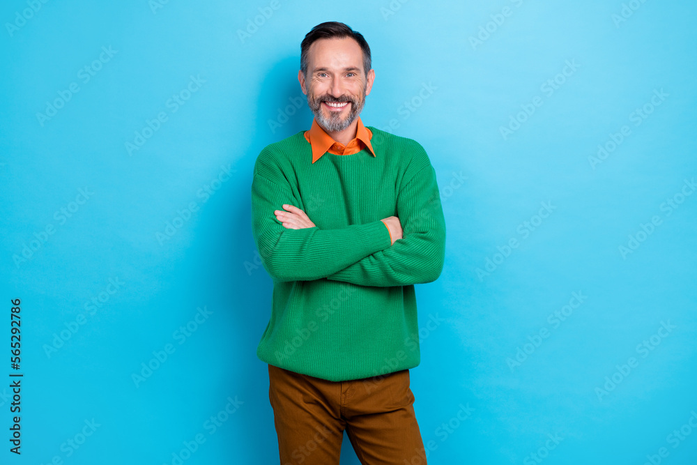 Photo portrait of mature handsome man crossed arms confident boss chief dressed stylish green clothes isolated on blue color background Photo portrait of mature handsome man crossed arms confident boss chief dressed stylish green clothes isolated on blue color background