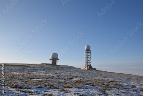 a view of the radar station at Titterstone Clee summit with the ground covered in snow and the sky clear blue