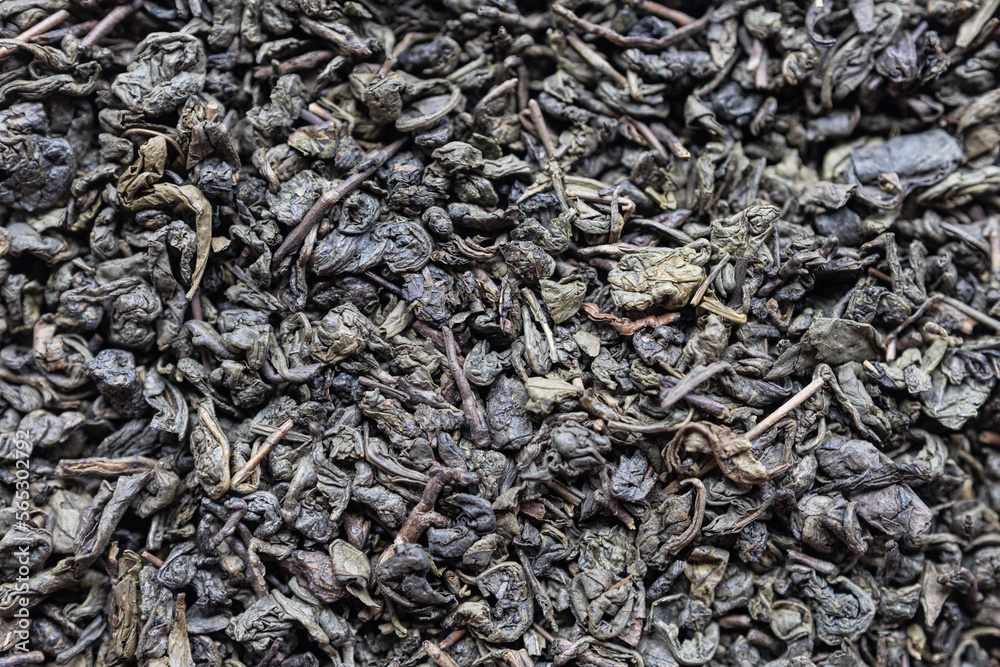 Large-leaf green tea is scattered on the table. Close-up. Large-leaf green tea is scattered on the table. Close-up.