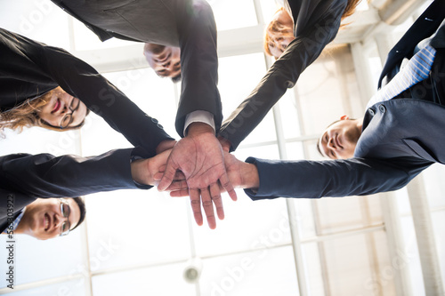 business people join fist bump hands together oneness under to top view. teamwork show by mix of circle bump fist hands for Spirit diversity solidarity team empower.