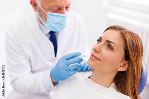 Doctor applying lip fillers to female patient