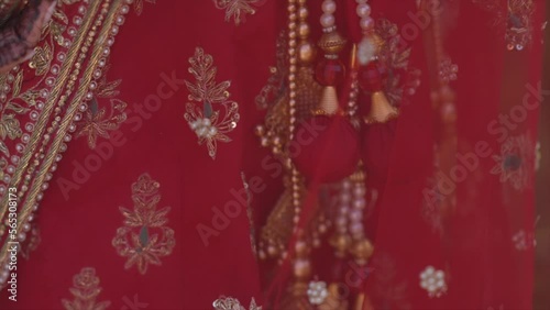 Groom tying cultural sacred thread on bride's hand at a traditional Indian wedding dress. Indian wedding ritual