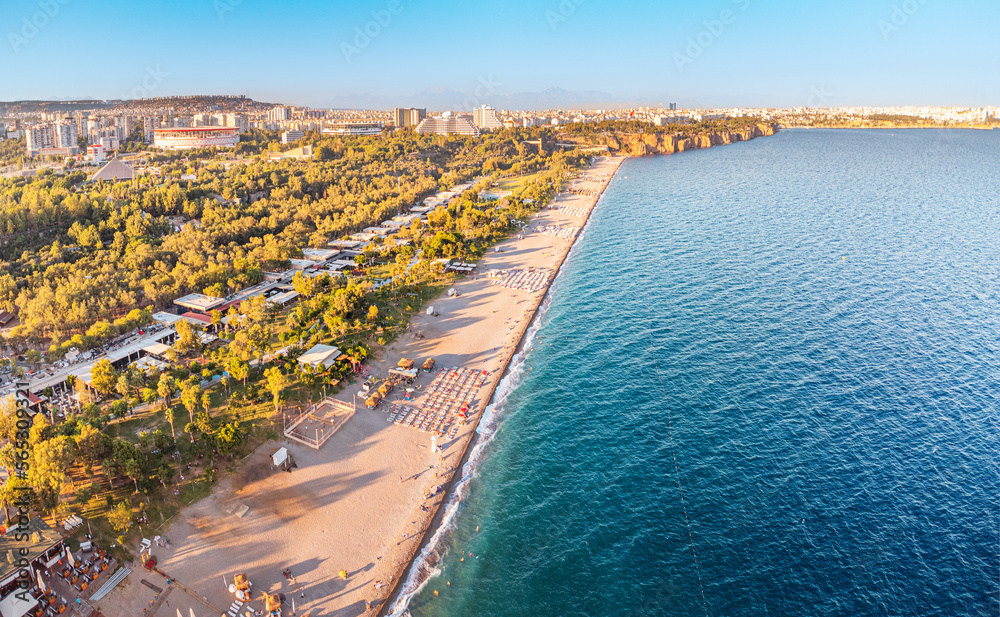 Aerial view of a sunset over beach park with vacationers in Antalya, Turkiye. Mediterranean sea coast and riviera.