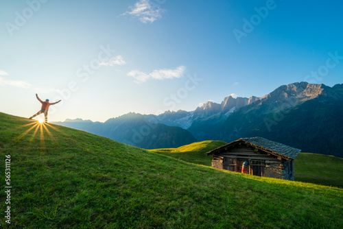 Rear view of man exulting at dawn, Tombal, Soglio, Switzerland photo