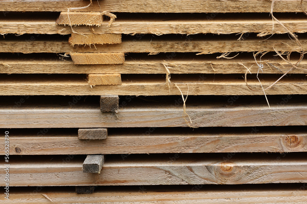 A close-up of a pile of planks at a sawmill. The distance between the planks allows them to dry properly.