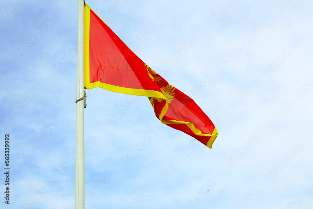 The national flag of Montenegro against a blue cloudy sky. The national flag of Montenegro against a blue cloudy sky.