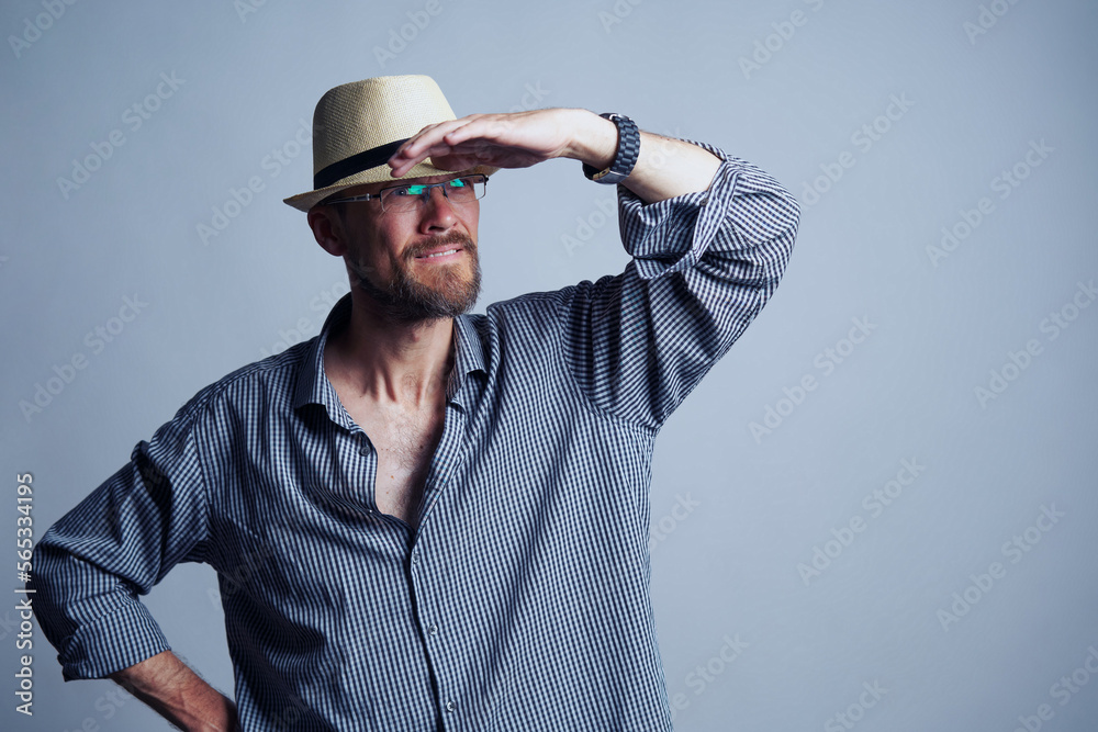 Mid age man in straw hat searching looking away with arm on his forehead