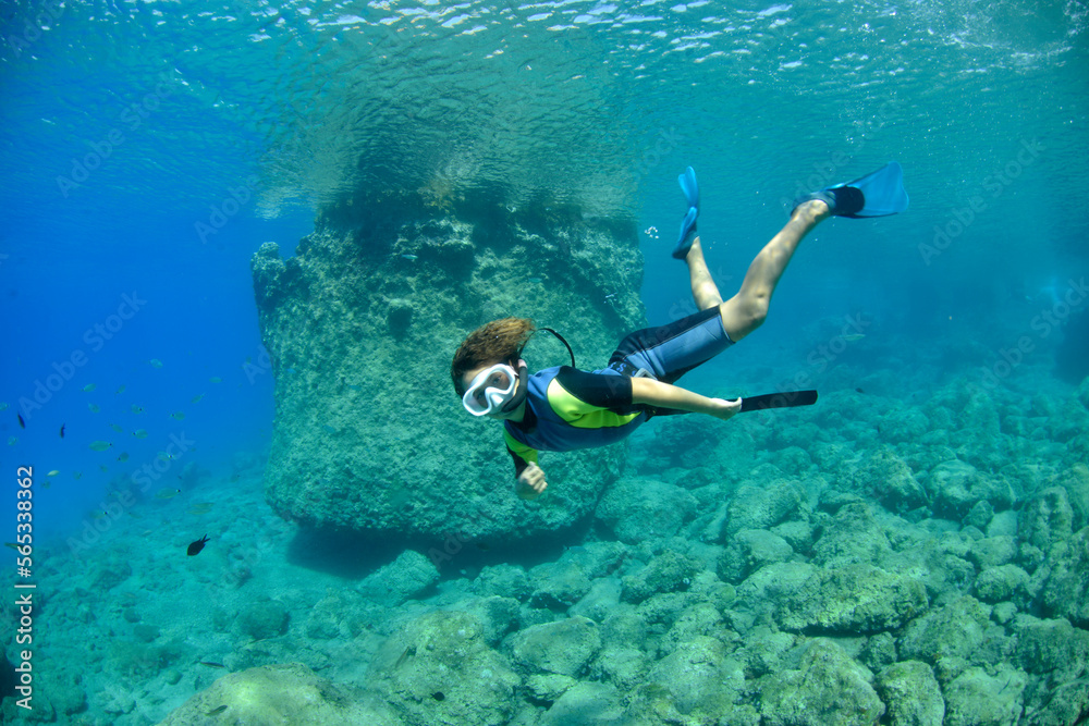 Fototapeta premium young boy snorkeling in clear waters