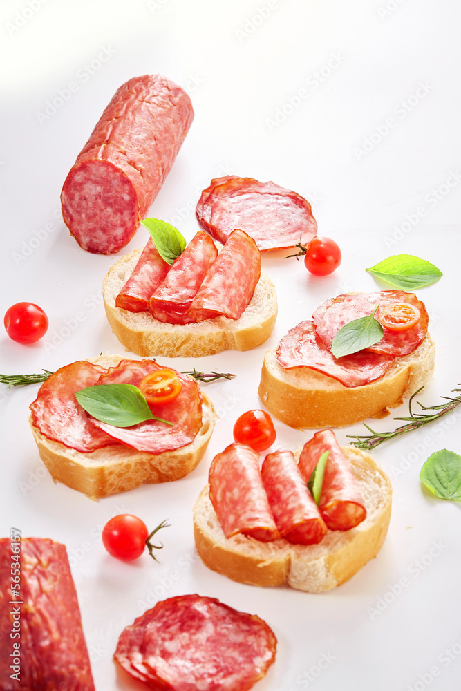 Smoked sausage salami with slices isolated on white background with clipping path. Top view with copy space for your text. Flat lay