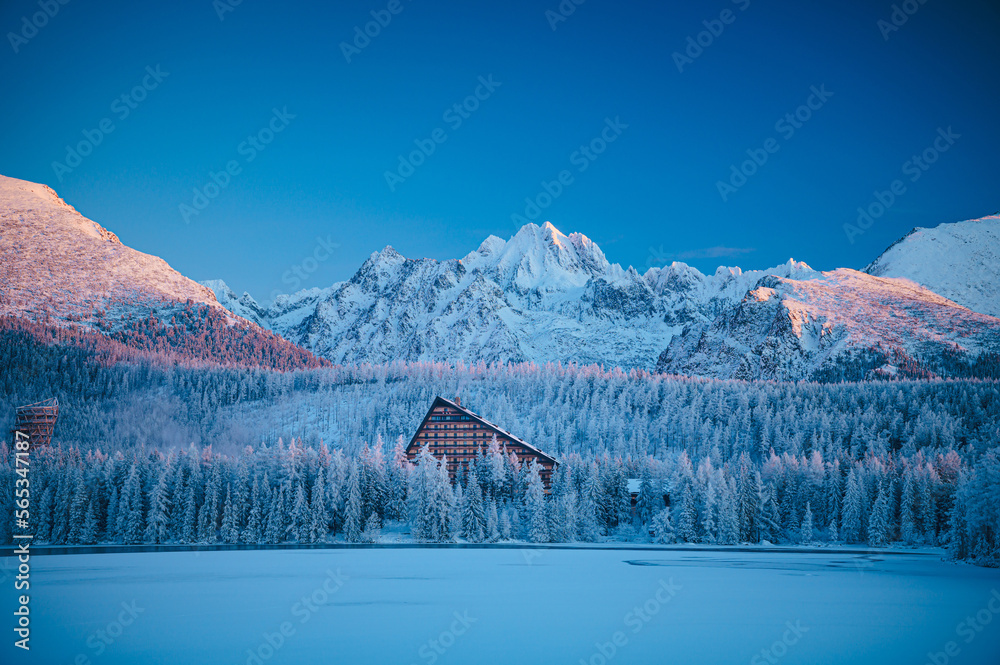 A peaceful and serene view of Strbske pleso lake surrounded by snow-capped High Tatras mountains