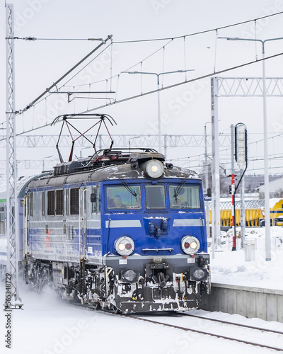 Train entering a snowy station in the winter