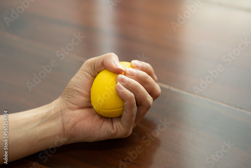 Hands of a woman squeezing a blue stress ball for work out or relax at home © tatomm