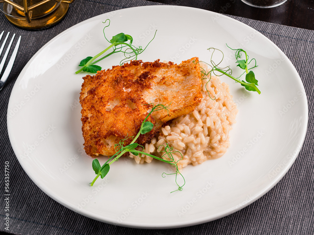 Italian risotto with fried white fish served with green peas. Italian risotto with fried white fish served with green peas.