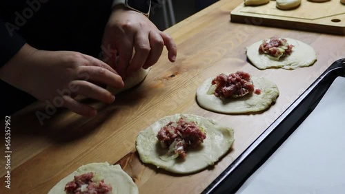 female hands put minced meat filling in puff pastry, homemade food, samsa making, traditional uzbek food