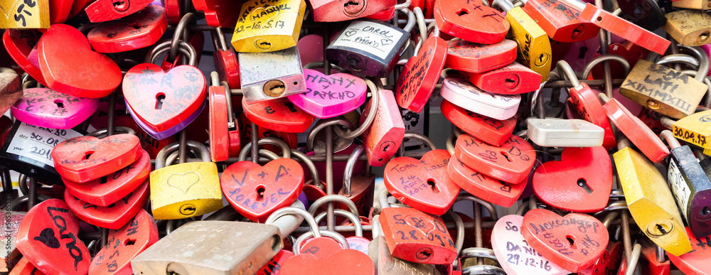 Verona, Italy - June 2022: background of heart-shaped locks on a wall, symbol of love forever.